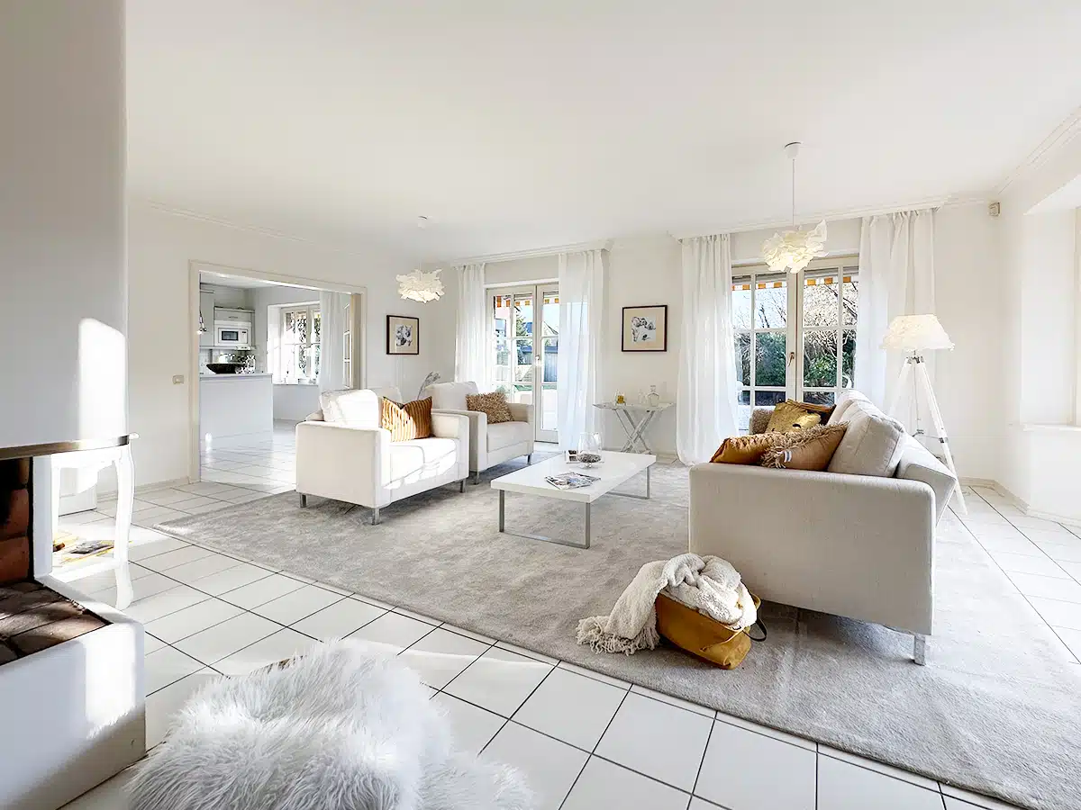 Offenes Wohnzimmer mit Kamin und Blick in den Garten